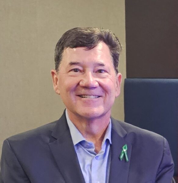 Derek is a white male wearing a navy blazer and smiling directly at the camera.